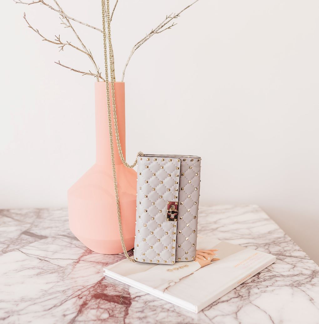 gently used Valentino handbag on a used coffee table book next to a secondhand vase