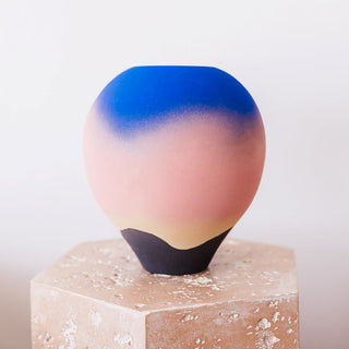 Studio Pottery Sunset Vase by Jan Twyerould placed on a faux stone pedestal