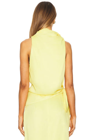 A woman shown from the back wearing a sleeveless pale yellow wrap-style dress against a plain white background.