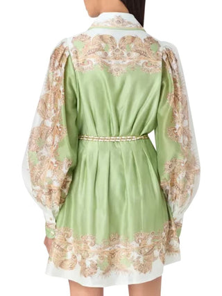 A light green satin mini dress with ornate beige and white baroque embroidery, featuring balloon sleeves and a matching waist tie, shown from the back on a model.