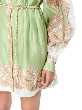 A close-up of a light green and white long-sleeve robe or dress with ornate gold paisley embroidery, featuring a braided gold belt and a drawstring front.