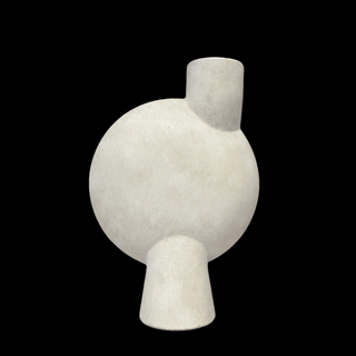 A matte finish, taupe-colored, asymmetric terracotta ceramic vessel with a curve-edge body displayed on a marble surface against a black background.
