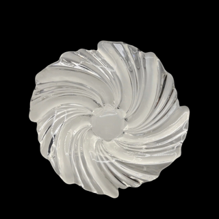 Clear and frosted glass decorative bowl with a swirling design on a black background