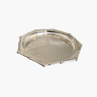 Silver tray with intricate designs on a white background
