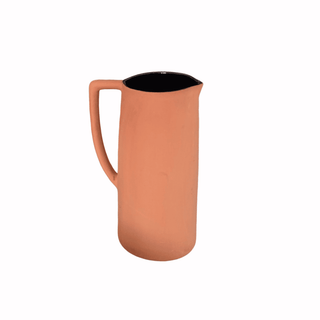 Terracotta-colored pitcher with a black interior on a white background